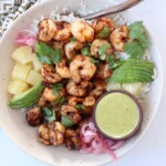 blackened shrimp in bowl with diced pineapple and honey lime dressing