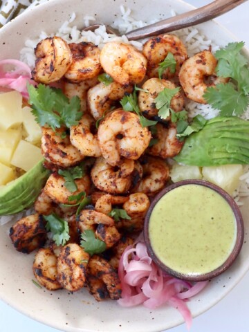 blackened shrimp in bowl with diced pineapple and honey lime dressing