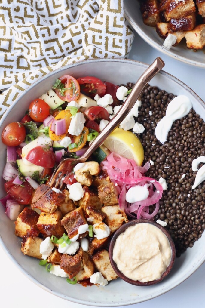 diced chicken in bowl with black lentils and fresh vegetables