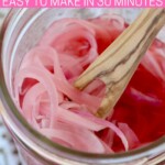 pickled red onions in jar with wooden fork