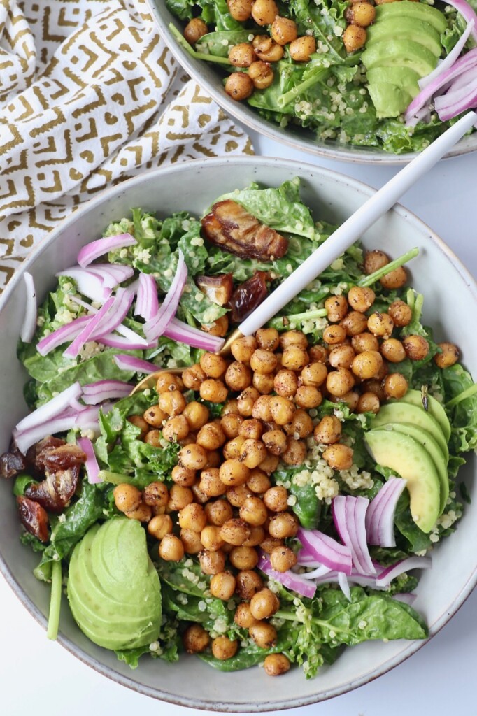 roasted chickpeas on top of salad in bowl with fork