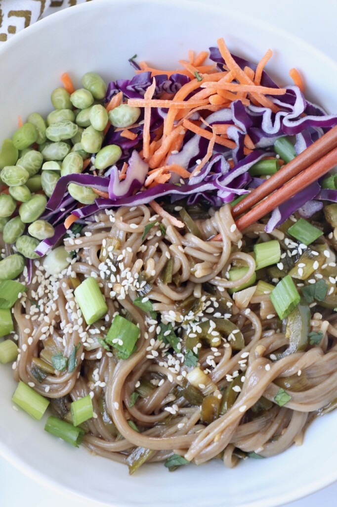 cooked soba noodles in bowl with vegetables and chopsticks