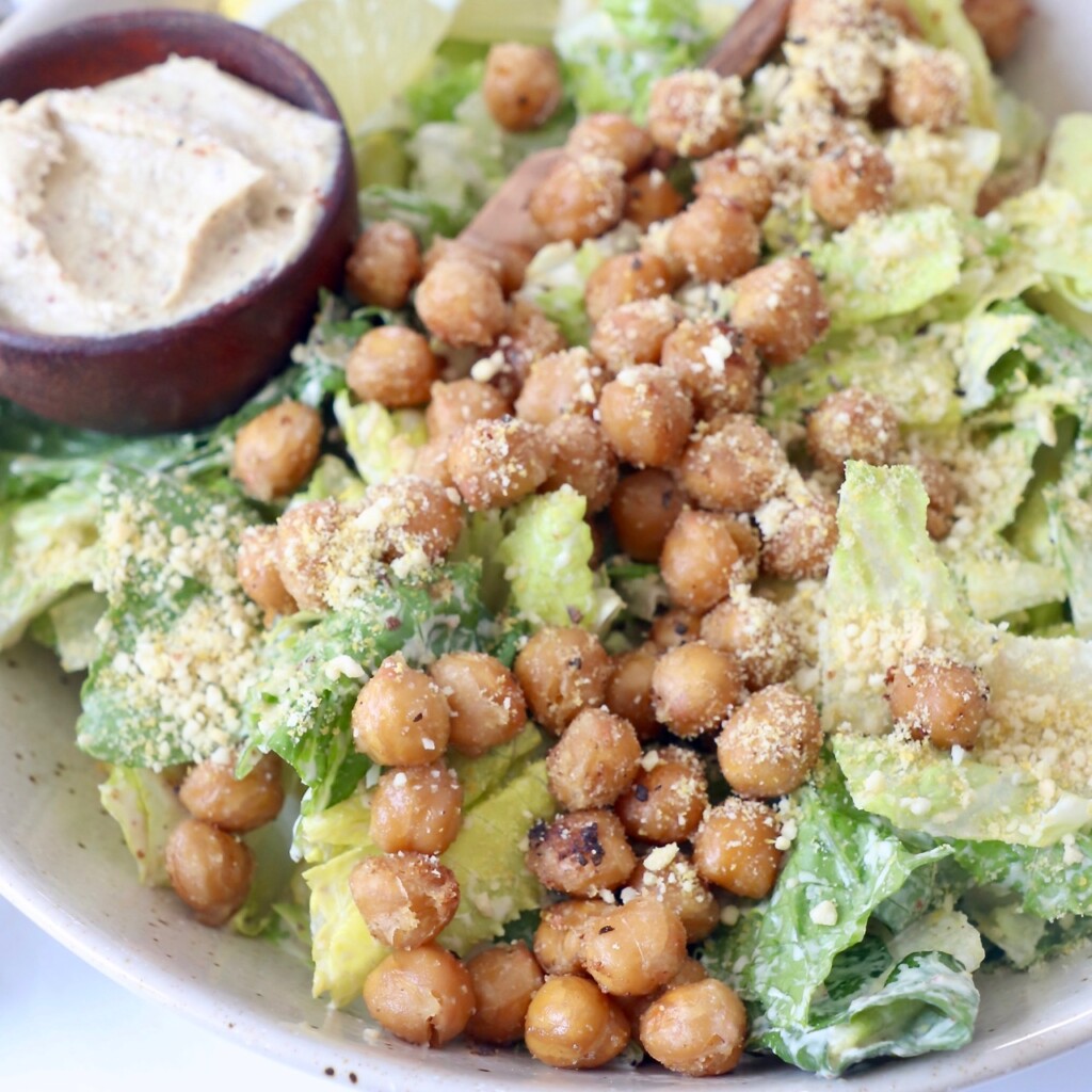vegan caesar salad in bowl topped with roasted chickpeas