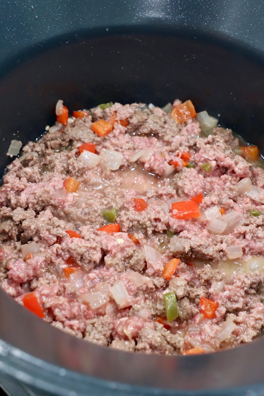 ground beef cooking in pot with vegetables