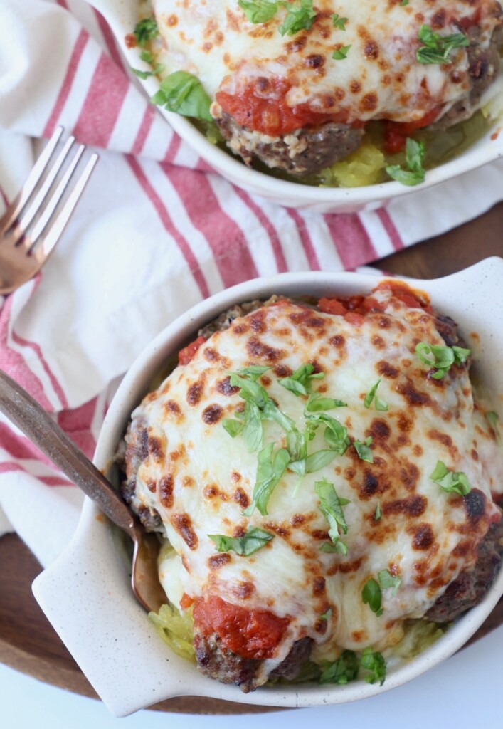 melted mozzarella cheese on meatballs in bowl with fork