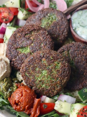 cooked falafel in bowl with veggies and sauce