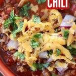 keto chili in bowl topped with shredded cheddar cheese