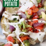 baked potato filled with roasted vegetables in bowl, topped with creamy garlic sauce