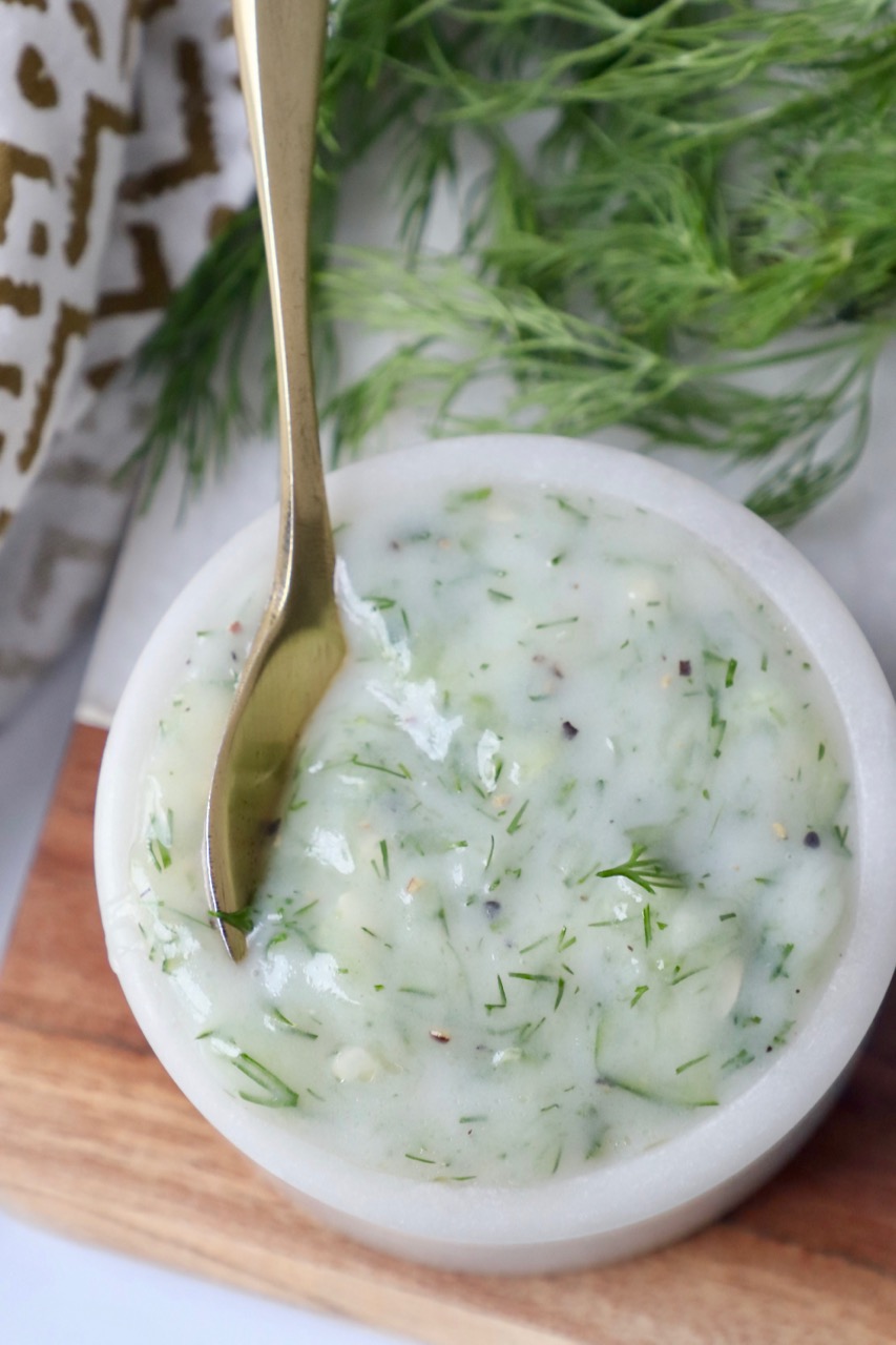 overhead image of tzatziki sauce in bowl with spoon
