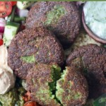 fried falafel patties in bowl with vegetables and sauce