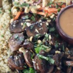 cooked sliced mushrooms in bowl with quinoa, slaw and peanut sauce